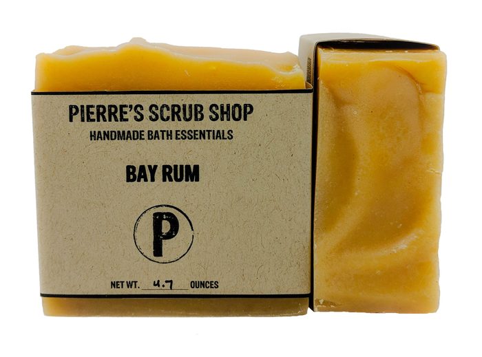 A Bay Rum bar in its kraft paper wrapper beside an unwrapped golden bar