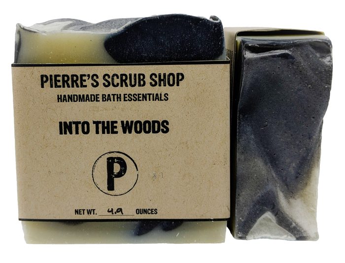 An Into the Woods bar in its kraft paper wrapper beside an unwrapped charcoal black bar