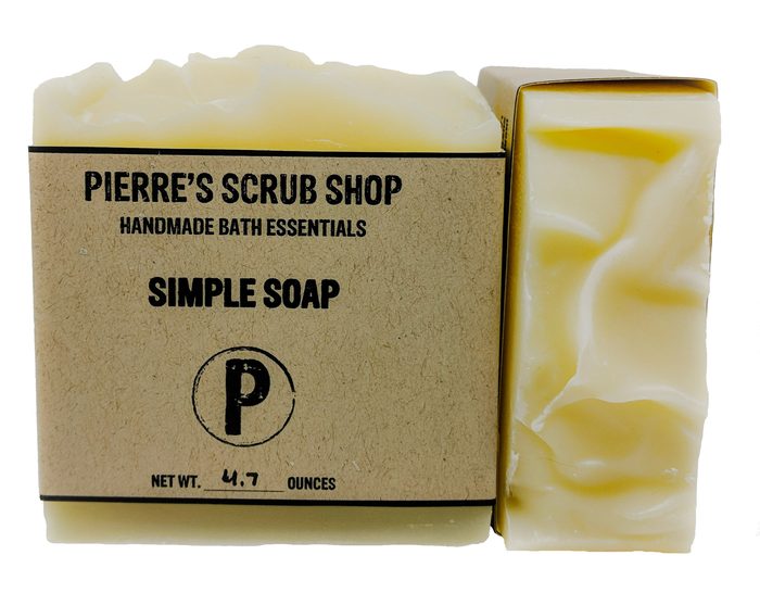 A Simple Soap bar in its kraft paper wrapper beside an unwrapped pale swirled bar